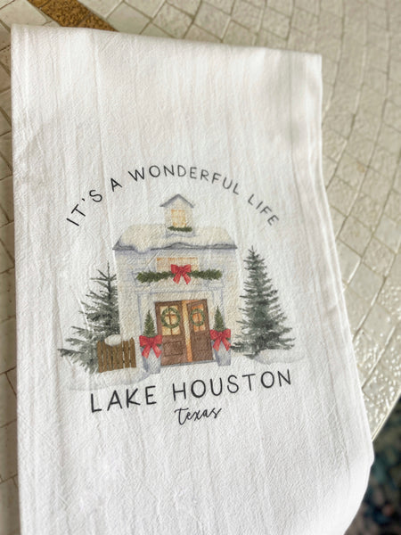 Decorative tea towel with Christmas-themed design and text that says It's a Wonderful Life Lake Houston TX